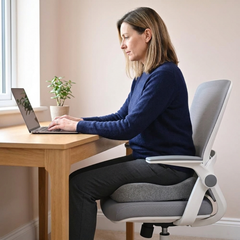 Coccyx cushion on an office desk chair while working at a laptop