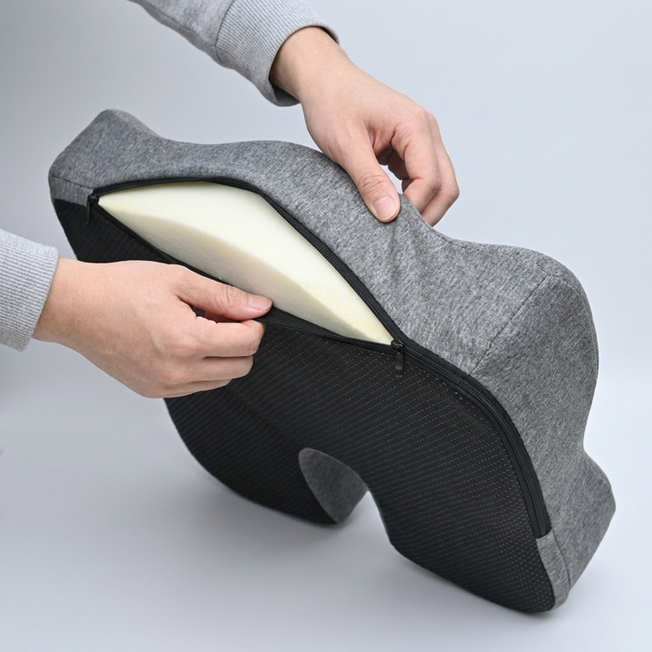 Unzipping the removable cover on the coccyx cushion to show the anti slip grip base