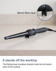 The curling wand resting on its folding heat insulation bracket with the hot barrel lifted clear of the worktop