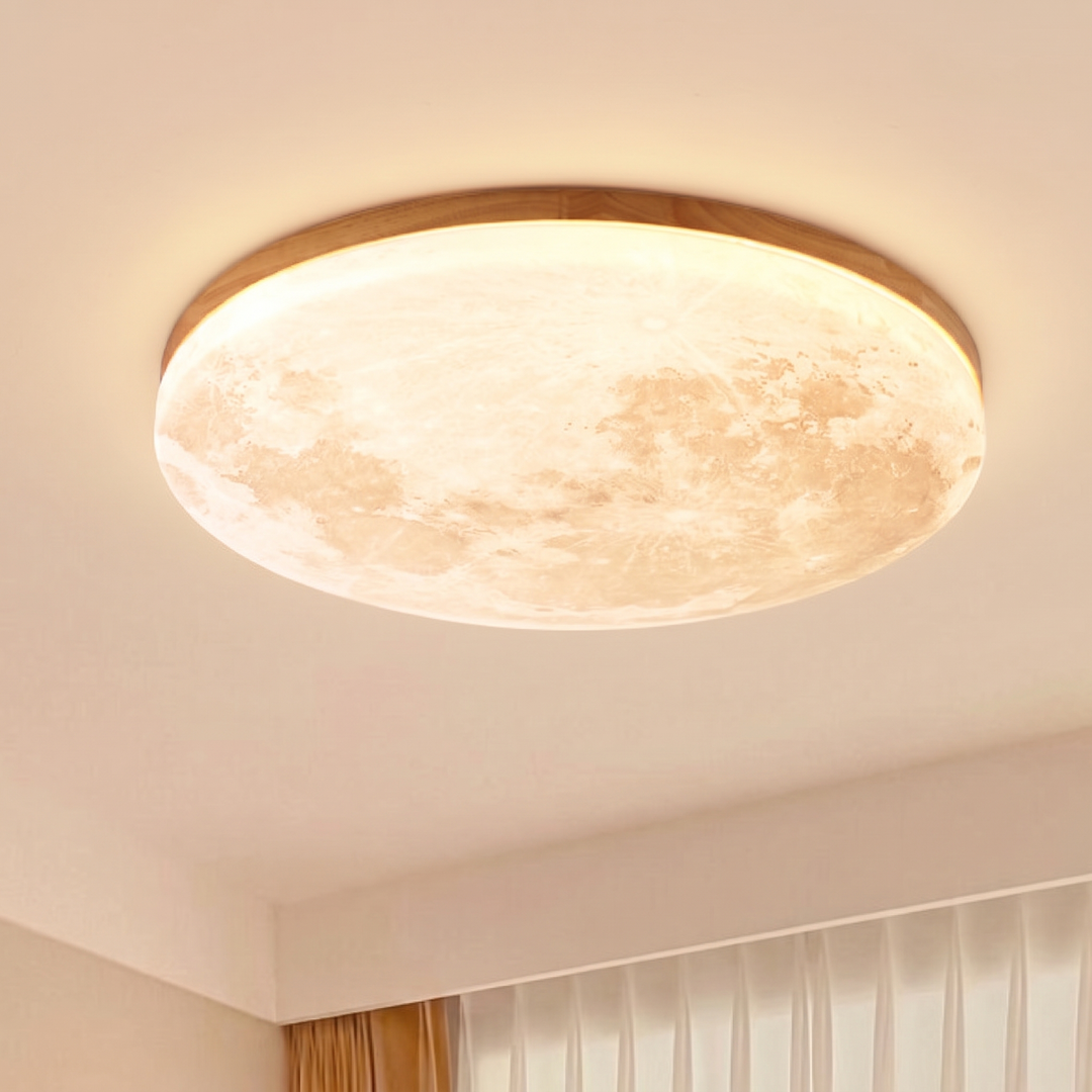 Light wood rim moon ceiling light glowing warm on a bedroom ceiling