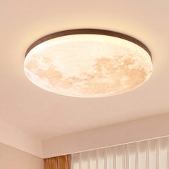 Dark wood rim moon ceiling light glowing warm on a bedroom ceiling