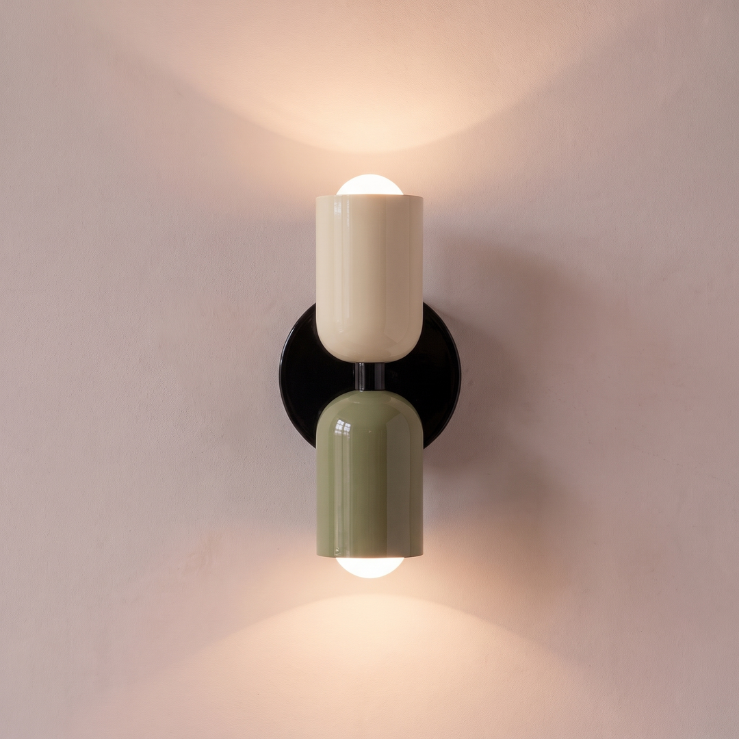 Cream and green two tone capsule wall light shining up and down, lit