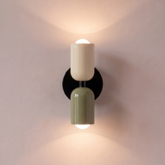 Cream and green two tone capsule wall light shining up and down, lit