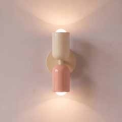 Cream and salmon two tone capsule wall light shining up and down, lit