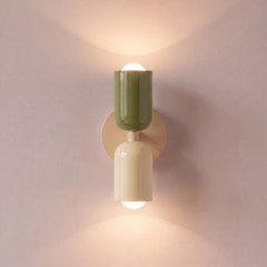 Green and cream two tone capsule wall light shining up and down, lit