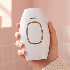 White handheld IPL hair removal device held in one hand