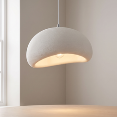 White textured mushroom pendant light glowing warm in a calm room with a wooden table below