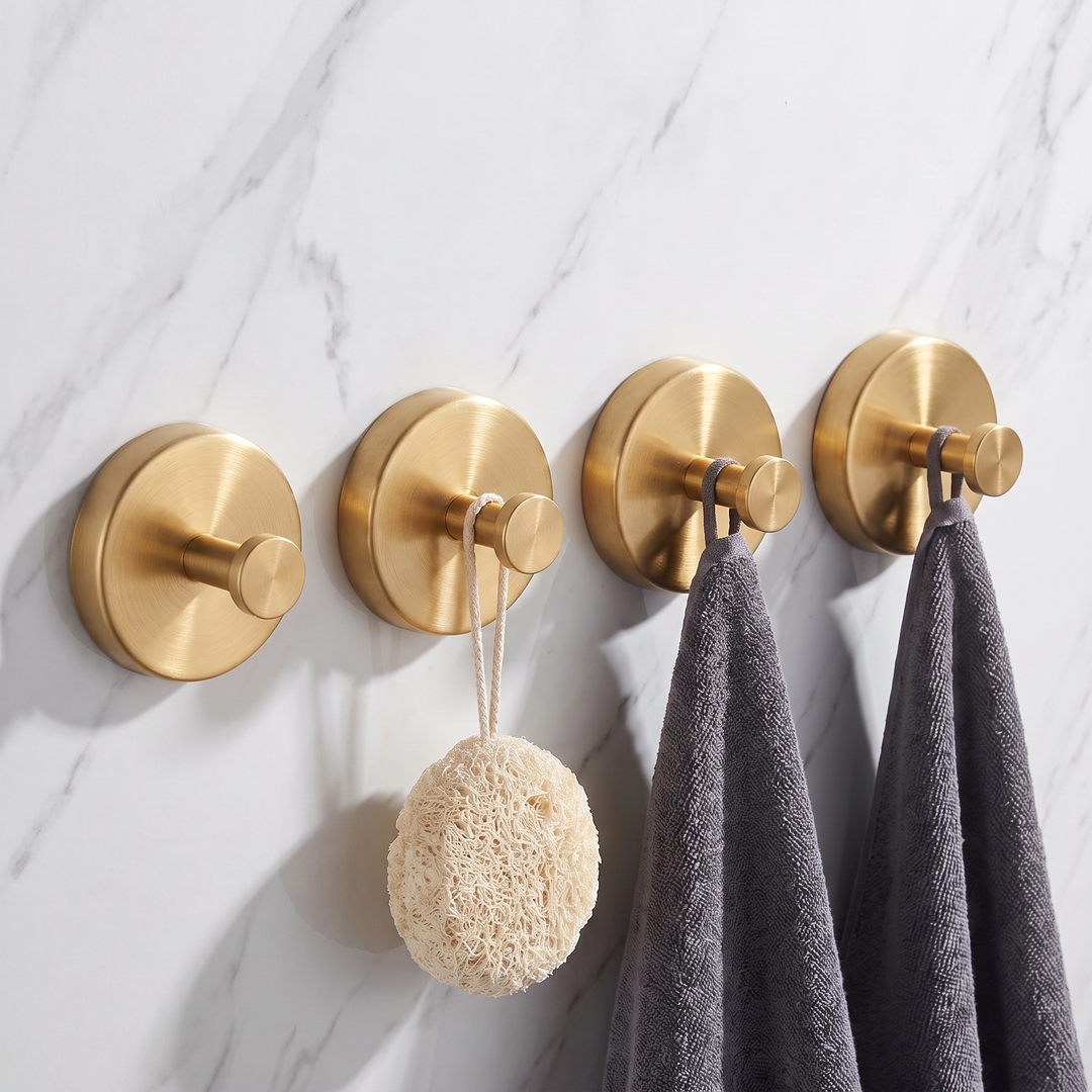 Brushed gold round suction hooks, pack of four, holding towels and a loofah on a marble wall
