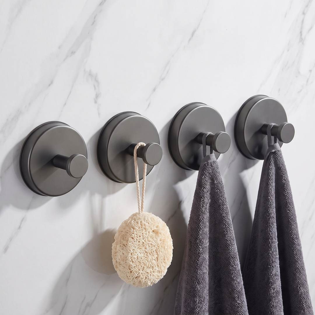Dark grey round suction hooks, pack of four, holding towels and a loofah on a marble wall