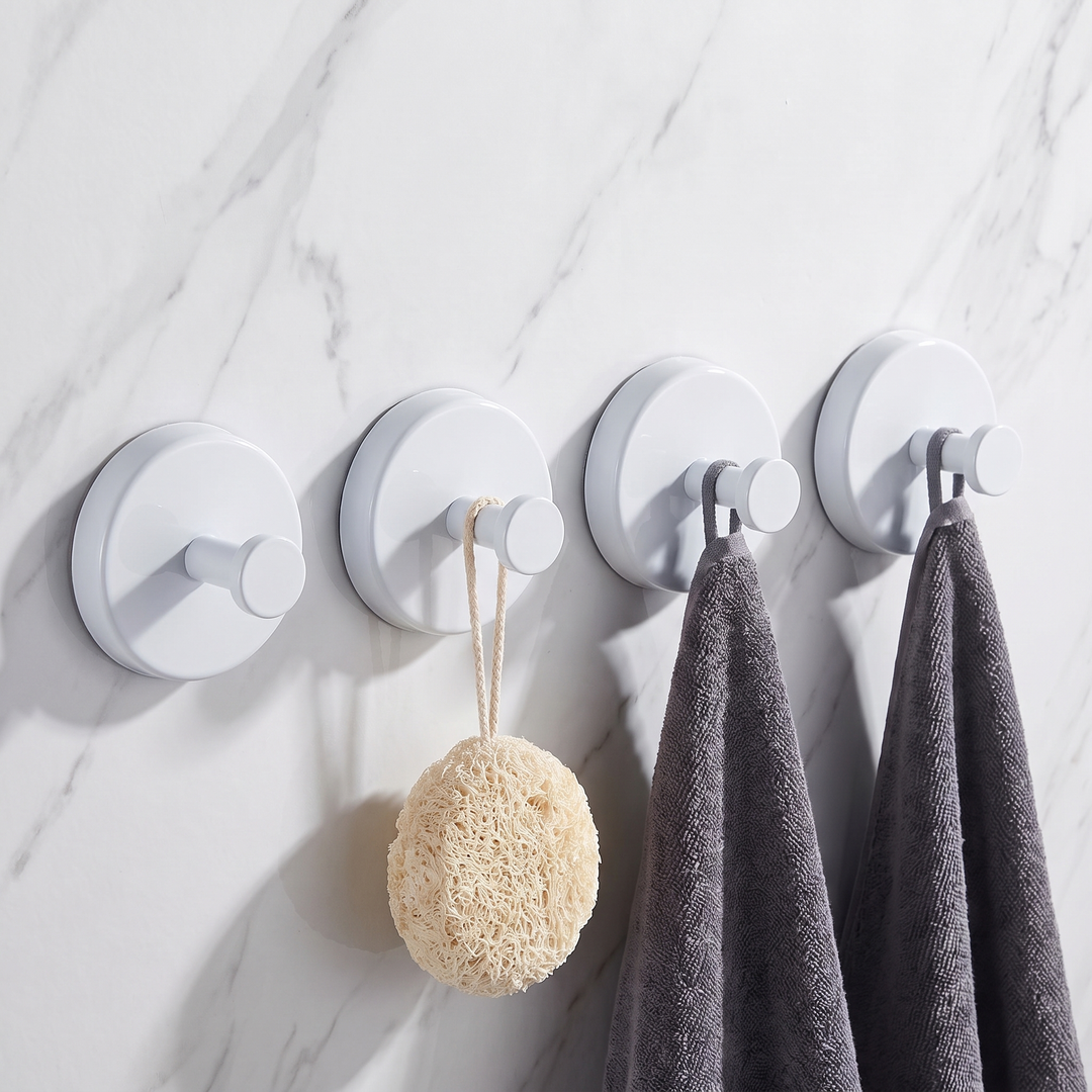 White round suction hooks, pack of four, holding towels and a loofah on a marble wall