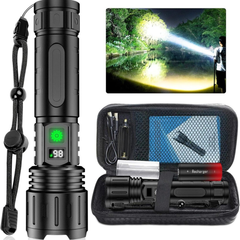 Black rechargeable LED torch held in a hand, beam lighting a woodland path at dusk