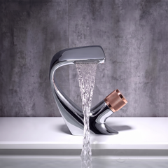 Chrome and Rose Gold curved waterfall basin mixer tap pouring a flat sheet of water