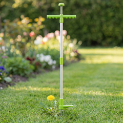 Stand up weed puller with lime green T handle and foot pedal on a lawn beside a dandelion