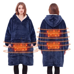Woman wearing a navy blue heated hoodie blanket with a sherpa lined hood in a bright living room