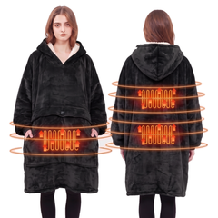 Woman wearing a black heated hoodie blanket with a sherpa lined hood in a bright living room