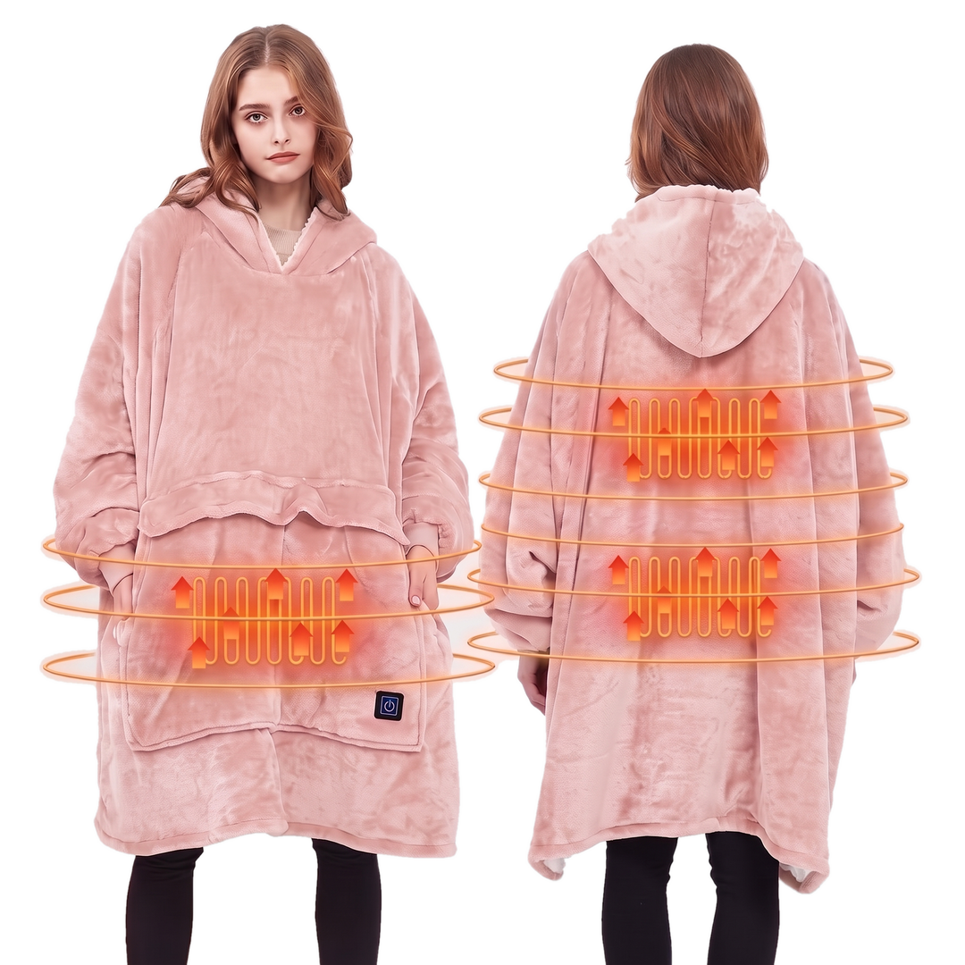 Woman wearing a pink heated hoodie blanket with a sherpa lined hood in a bright living room