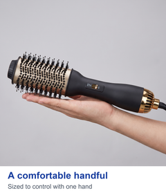 Hot air styling brush held in a hand to show scale