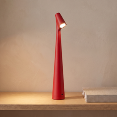 Red cordless rechargeable table lamp on a console table