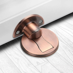 Red Bronze magnetic stainless steel door stop on an oak floor at the bottom of an open door
