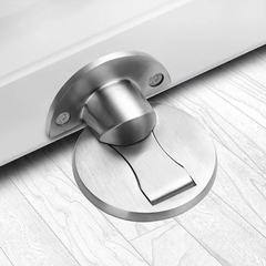 Brushed Silver magnetic stainless steel door stop on an oak floor at the bottom of an open door