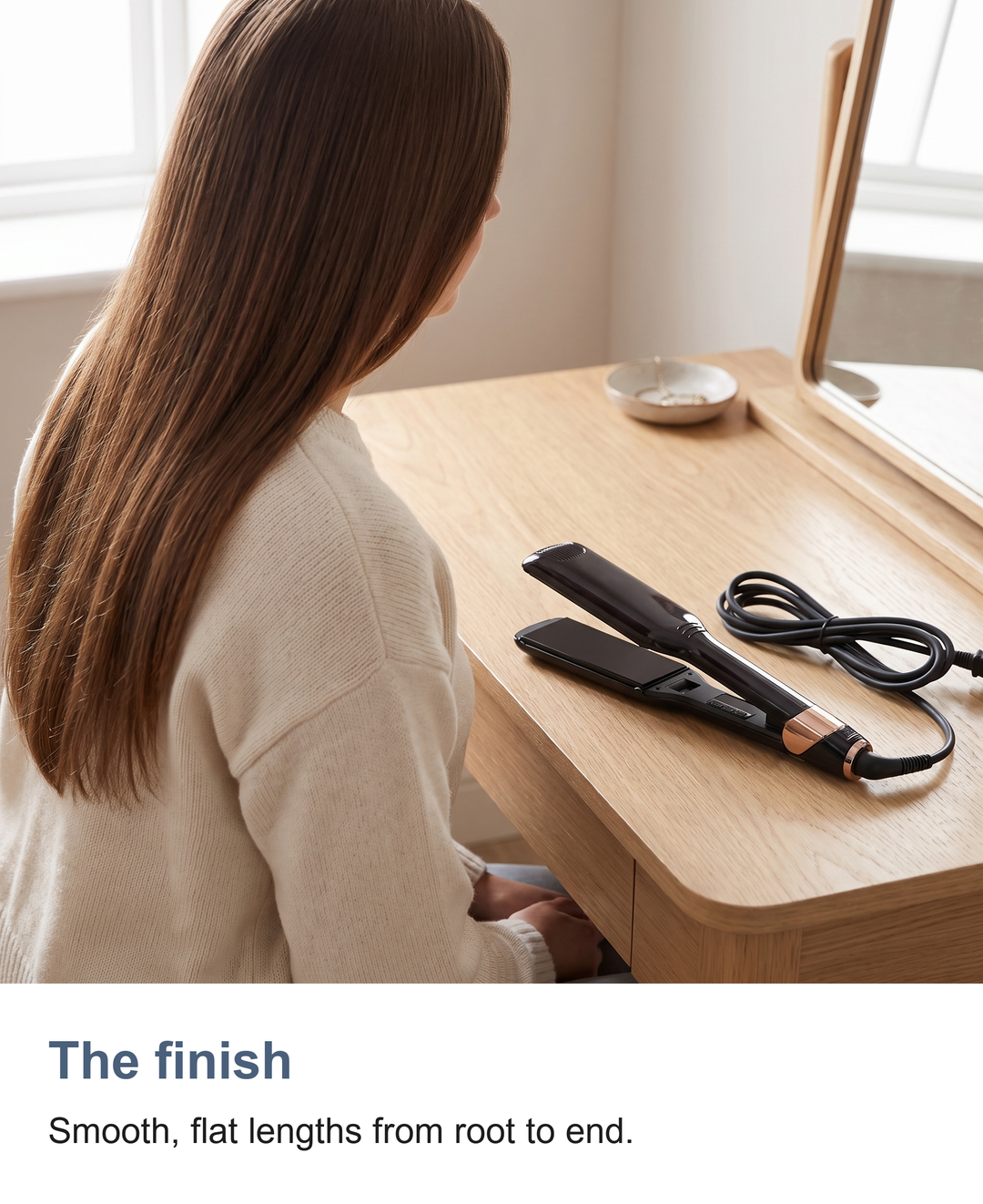 Smooth straightened hair with the ceramic hair straightener resting on the dressing table