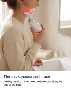 A woman in a cream crew neck jumper resting the neck massager head against the side of her neck