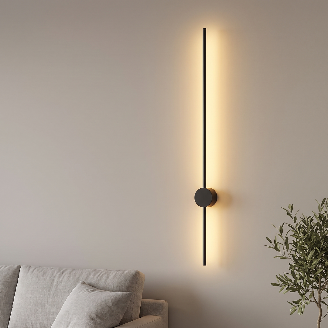 Black linear LED wall light glowing warm on a living room wall
