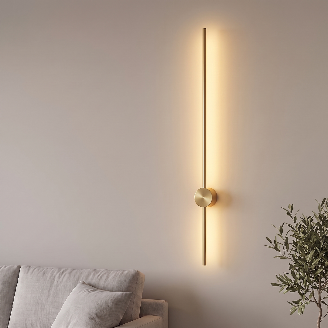 Gold linear LED wall light glowing warm on a living room wall