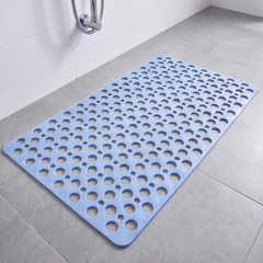 Blue non slip shower mat with suction cups and drainage holes on a shower floor