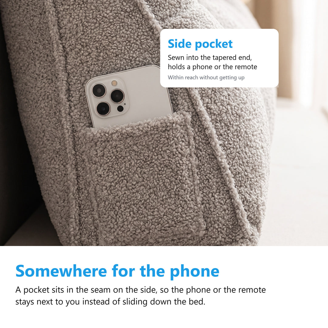 Close up of the side pocket on a headboard bolster cushion with a phone tucked inside