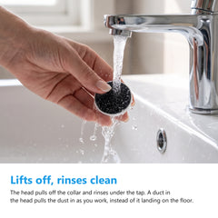Detachable head of the electric foot file being rinsed clean under a bathroom tap
