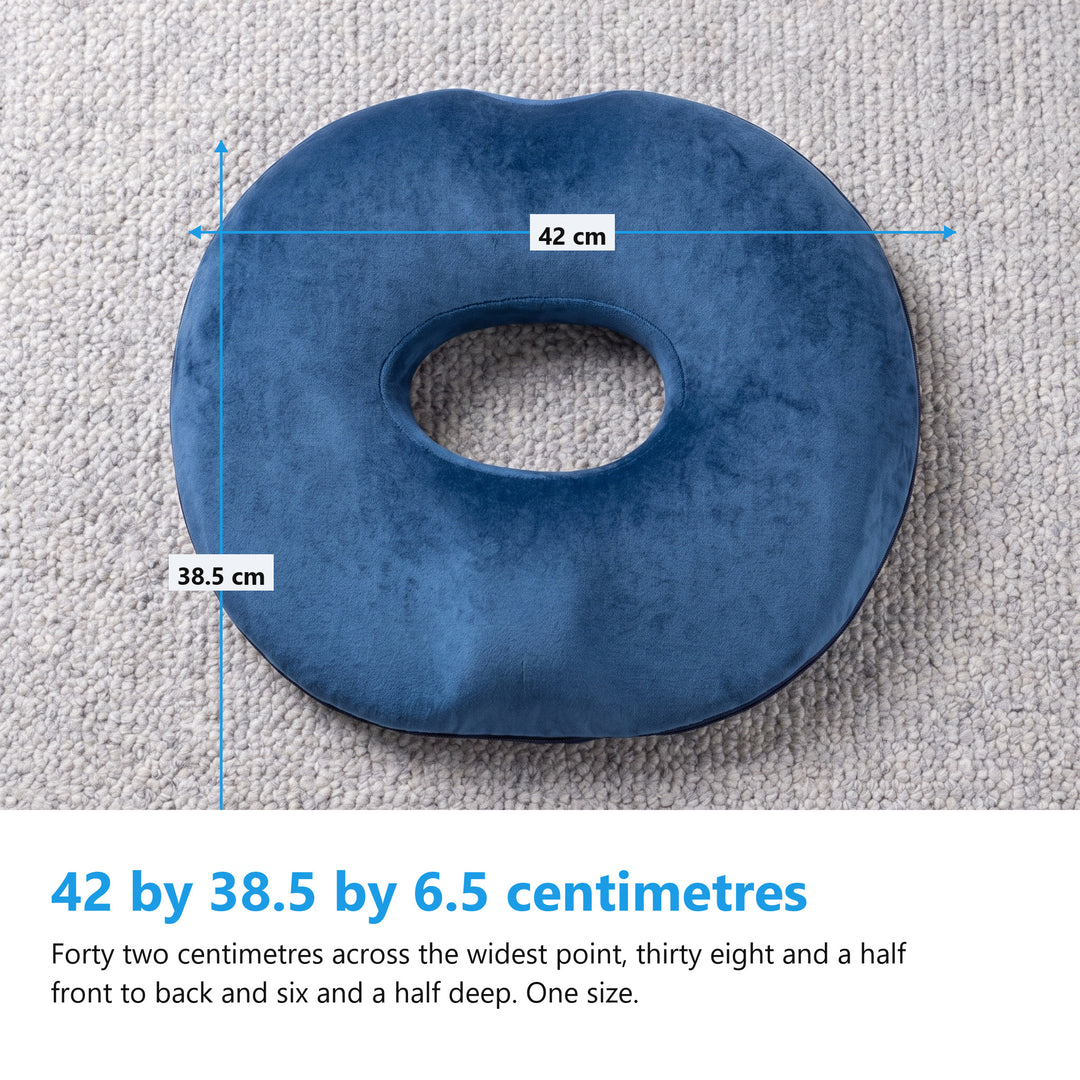 Navy donut cushion flat on a grey wool rug with measurement arrows reading 42 cm across and 38.5 cm front to back