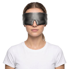 Woman wearing the charcoal 3D contoured silk eye mask on a white background, the wide silk band covering both eyes and temples