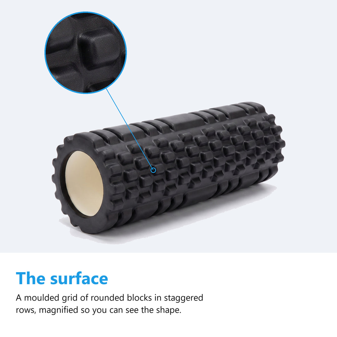 Black textured foam roller on a plain blue background with a magnified circle showing the rounded moulded blocks in staggered rows and the deep channels between them