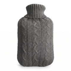 Hot water bottle with a grey knitted cable cover on a white background