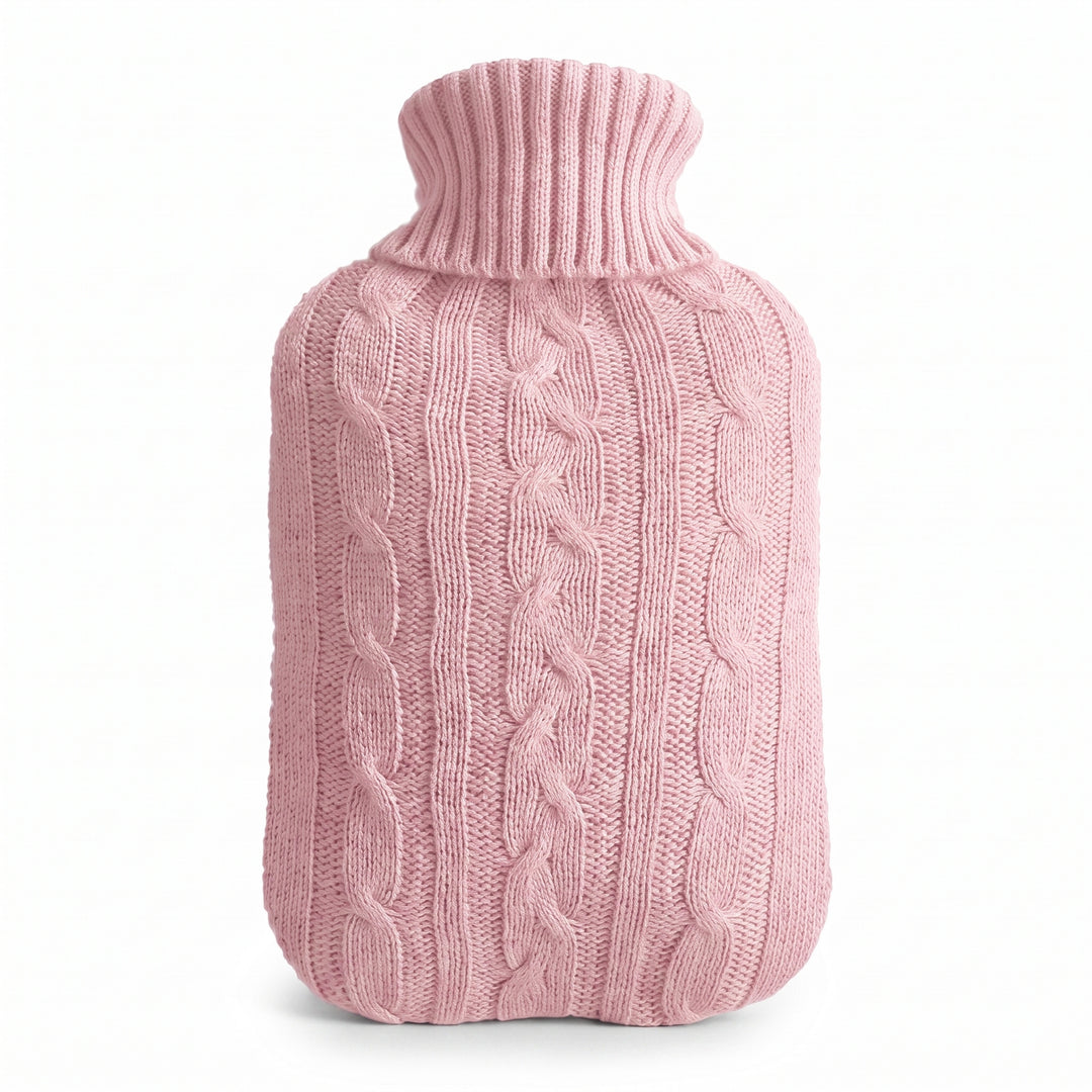 Hot water bottle with a pink knitted cable cover on a white background