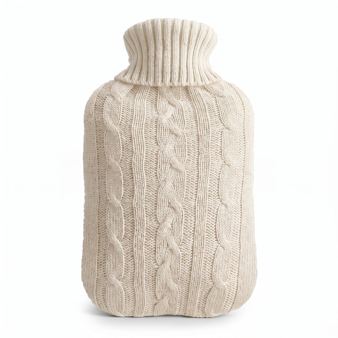 Hot water bottle with a white knitted cable cover on a white background