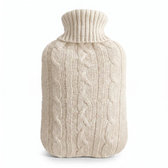 Hot water bottle with a white knitted cable cover on a white background