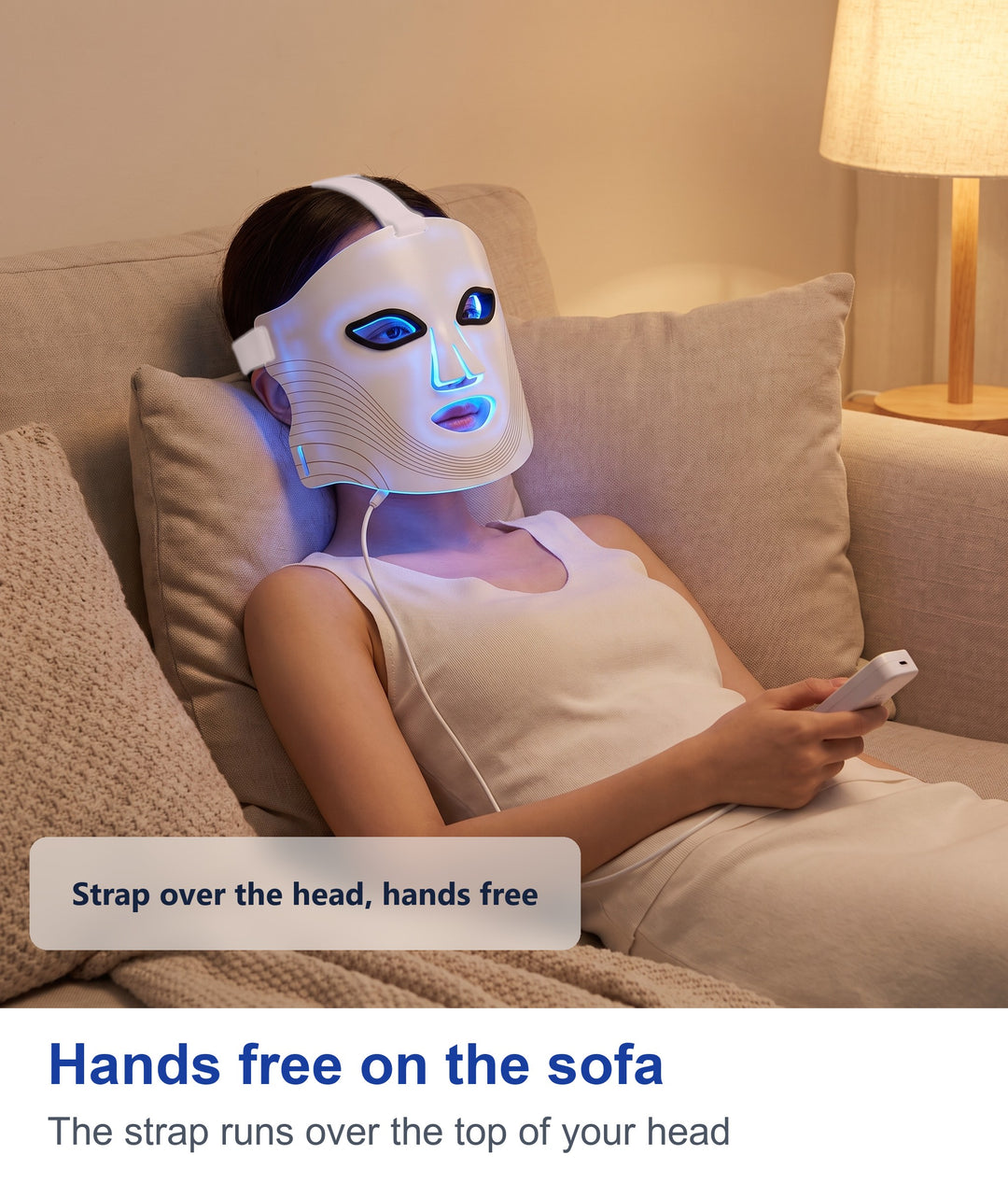 Woman relaxing on a sofa wearing the white LED face mask