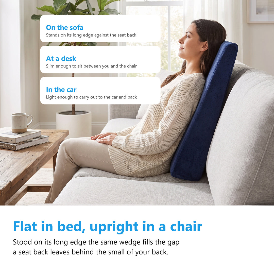 Woman sitting on a sofa with the navy velvet wedge cushion standing on its long edge behind her lower back