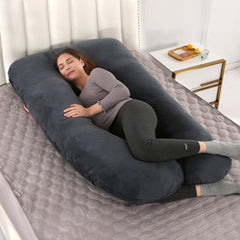 U shaped pregnancy pillow in black velvet laid out on a bed