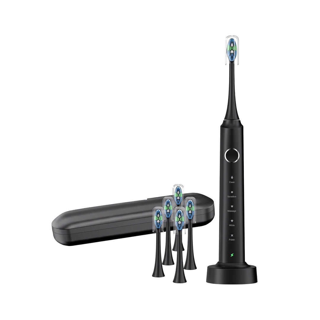 Black electric toothbrush upright on its wireless charging base with its travel case and five spare brush heads on a white background