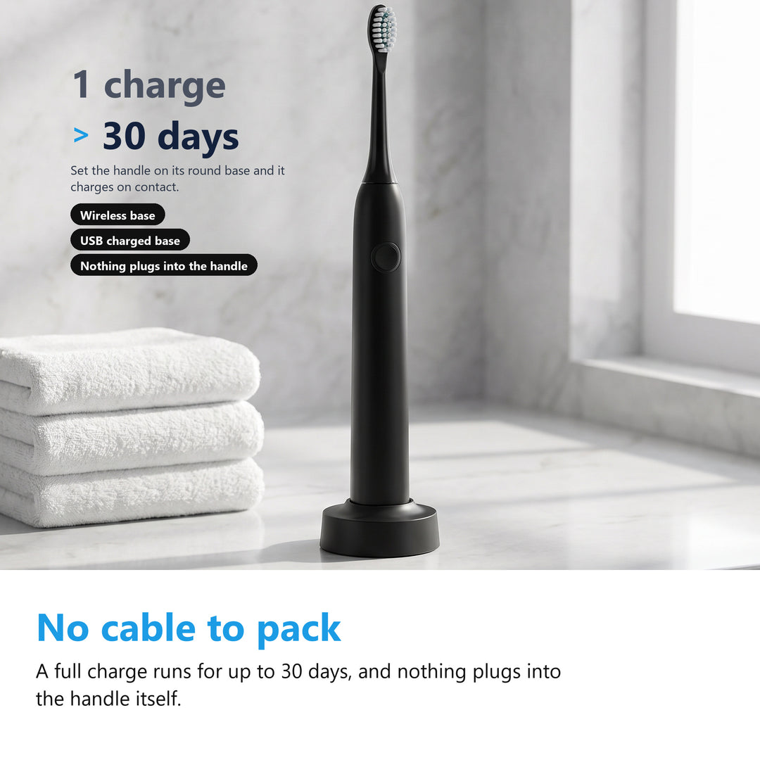 Black electric toothbrush on its wireless charging base on a bathroom counter