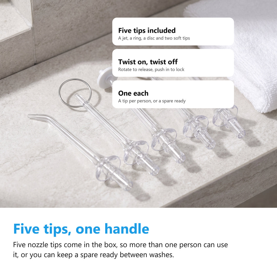 The five nozzle tips supplied with the cordless water flosser laid out on a bathroom shelf