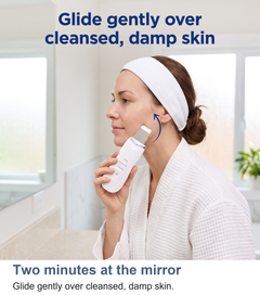 Woman gliding the ultrasonic skin scrubber gently over cleansed, damp skin