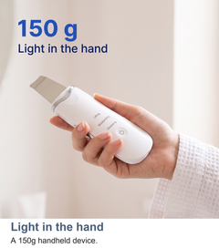Ultrasonic skin scrubber held in a palm showing its 150g weight